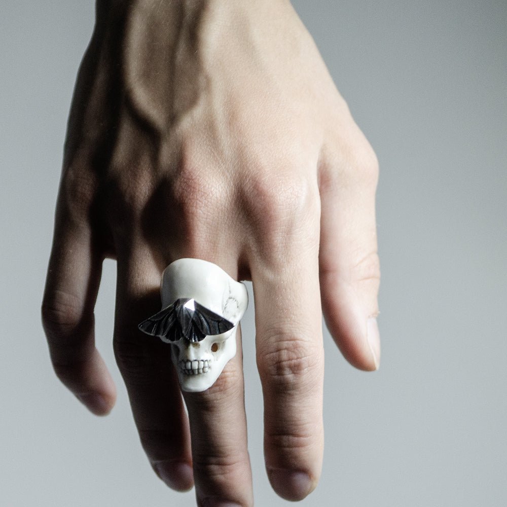 Skull & Moth ring - white variant - on a model's hand under semi-contrast light