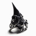 This image features a distinct and artistic "Talon ring," crafted from raw finished oxidised sterling silver (925). The ring showcases an intricate design that blends both traditional and modern elements, highlighting a dark, gothic aesthetic with a prominent  ornate scrollwork.