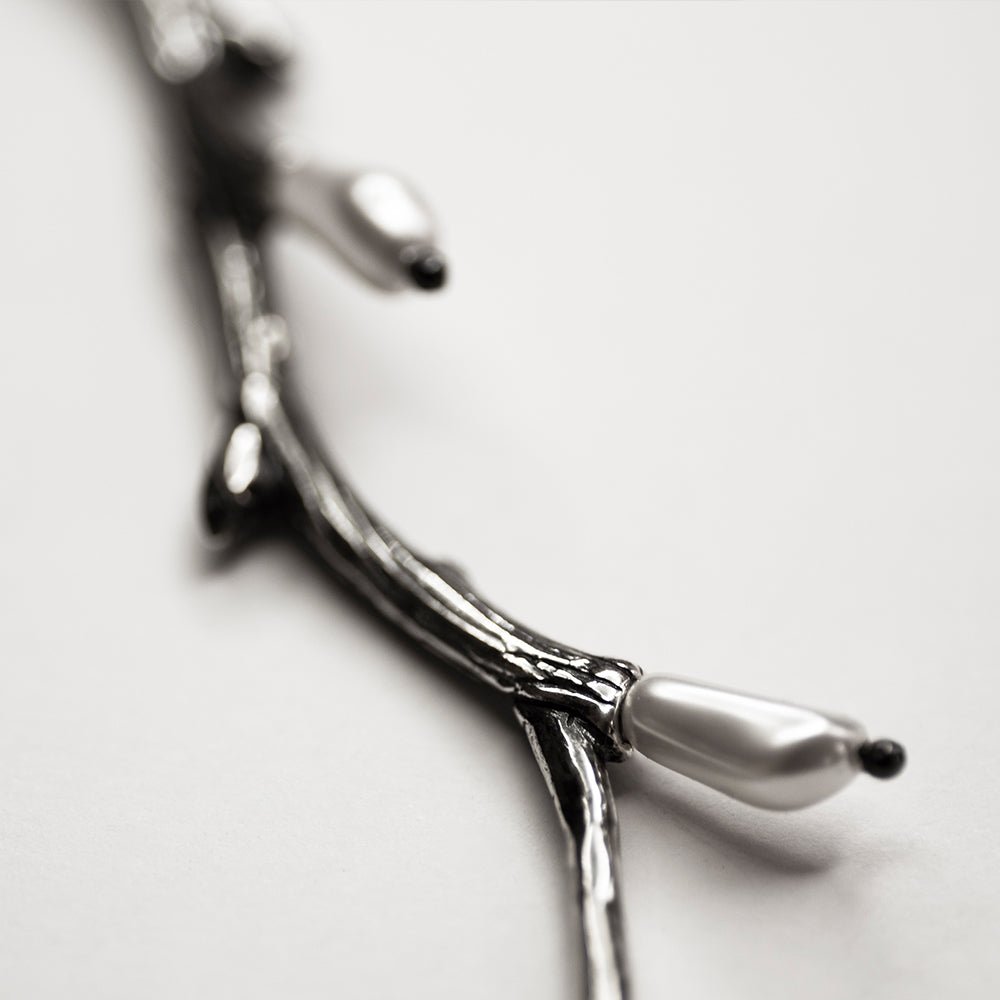 Silver Twig pendant close up on a pearl detail 