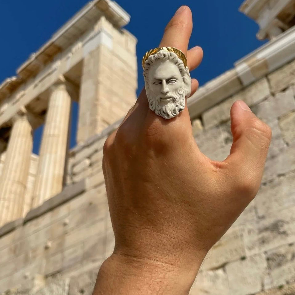 Zeus ring on male hand against ancient temple ruins 